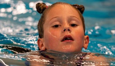 meisje met twee knotjes zwemt schoolslag