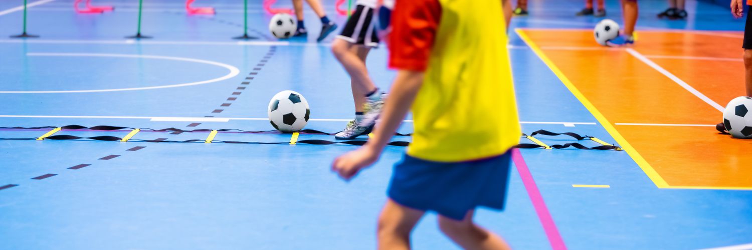 Voetballende kinderen in een sportzaal