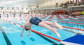 Twee jongens duiken het water in voor een wedstrijd wedstrijdzwemmen