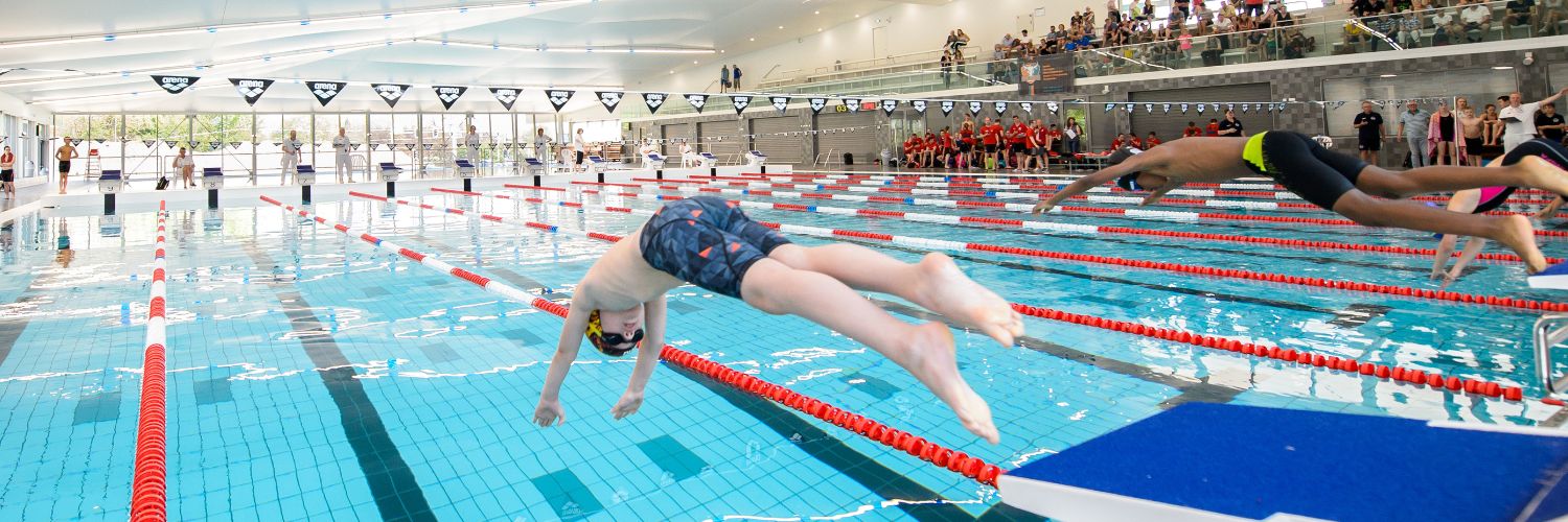 Twee jongens duiken het water in voor een wedstrijd wedstrijdzwemmen